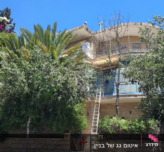 בניין עם סולם ועבודות על הגג ביום שמשי